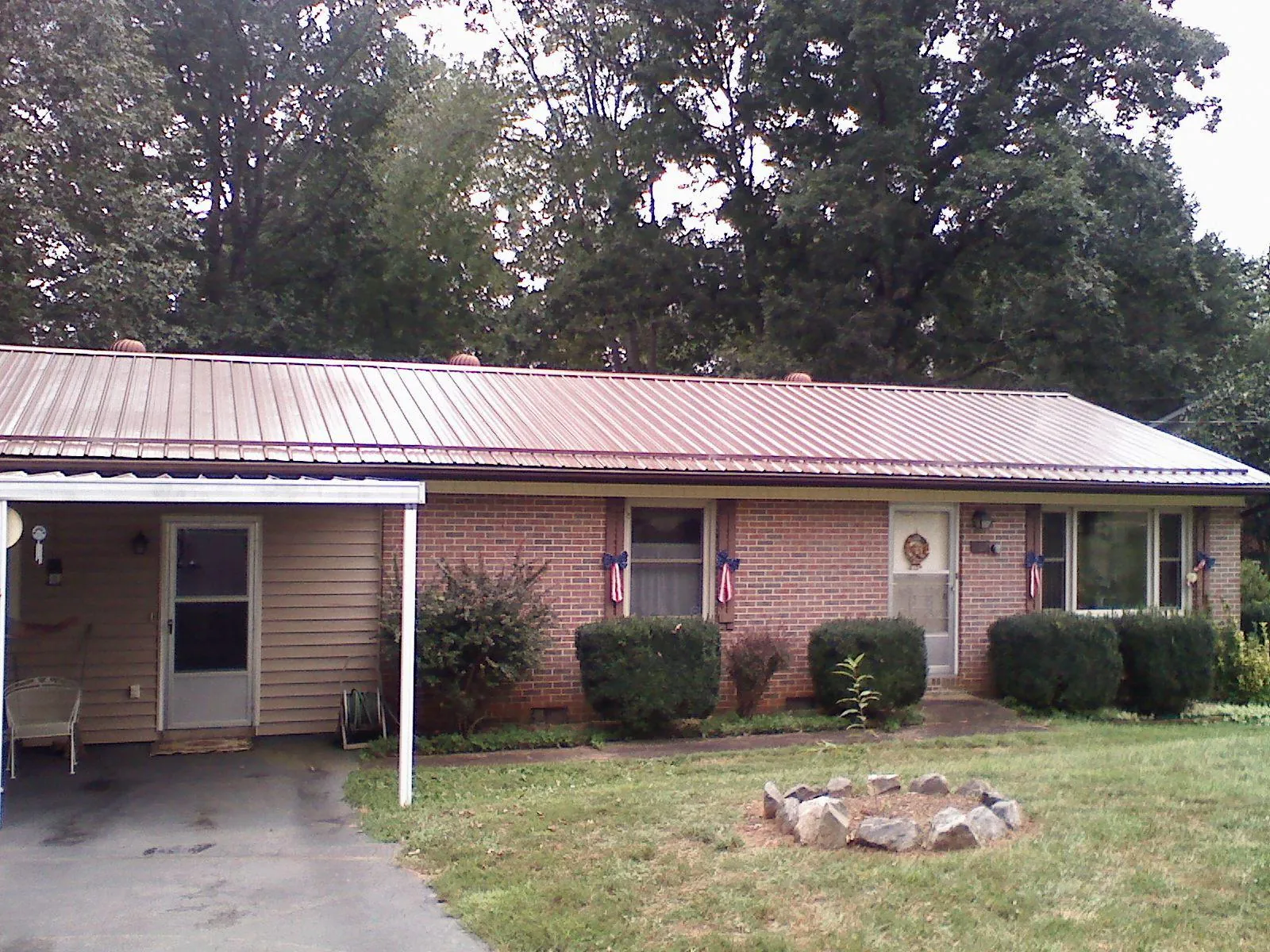 Bronze metal roof and carport on a brick ranch home — Roof Repair work by our crew in Pooler